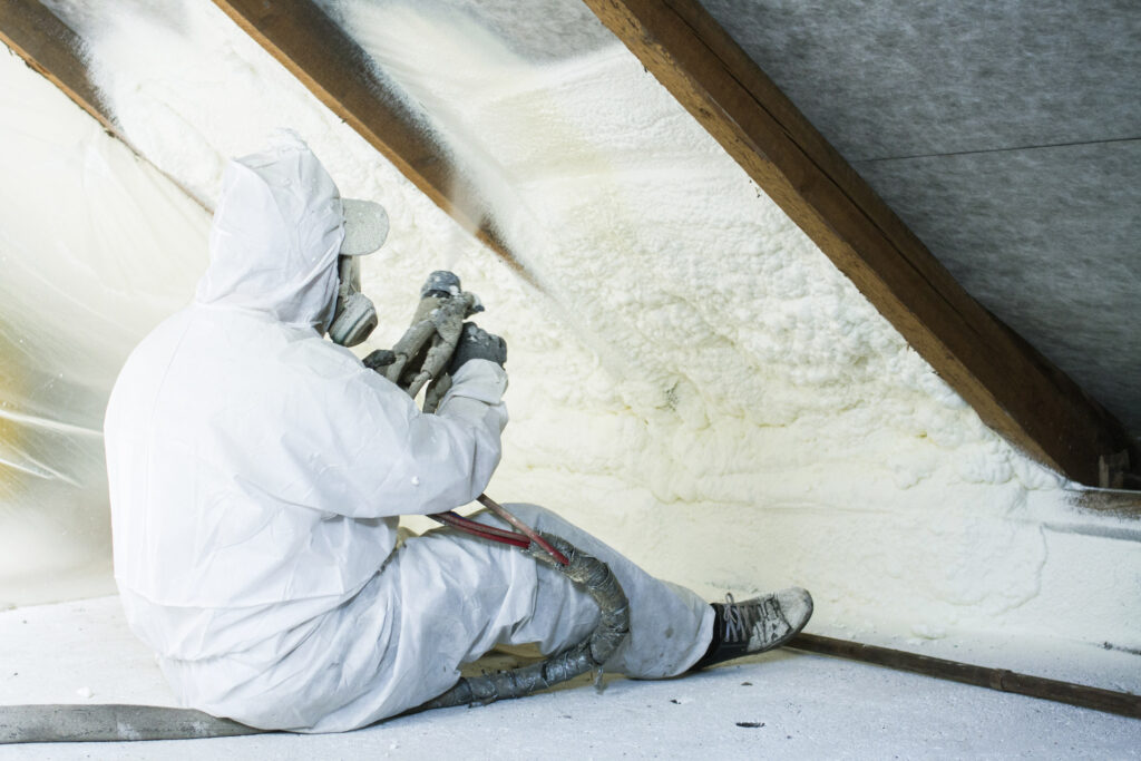 Spray foam insulation being installed by ArmorGuard in the attic of a home.