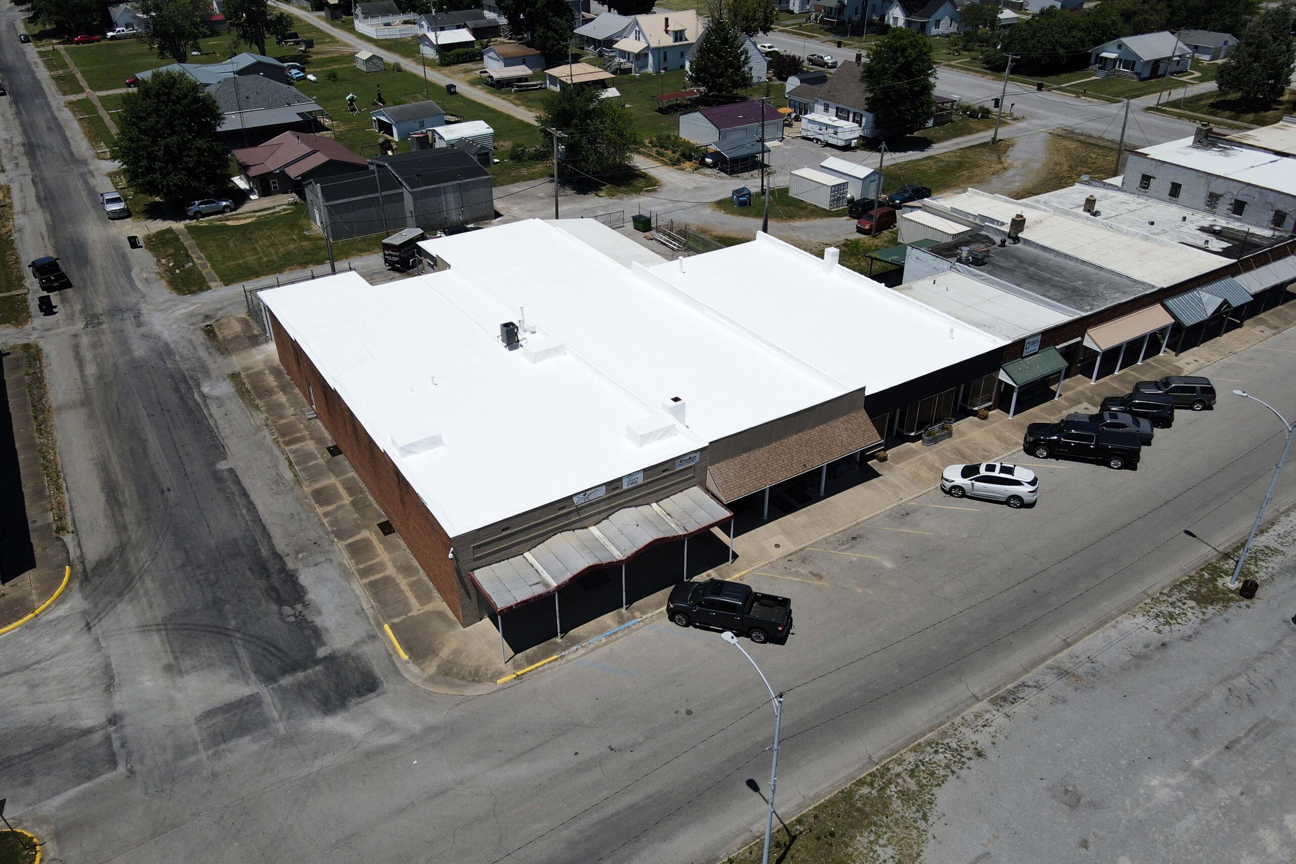 Aerial view of completed installation of a cool roofing system to the roof of a business by ArmorGuard.