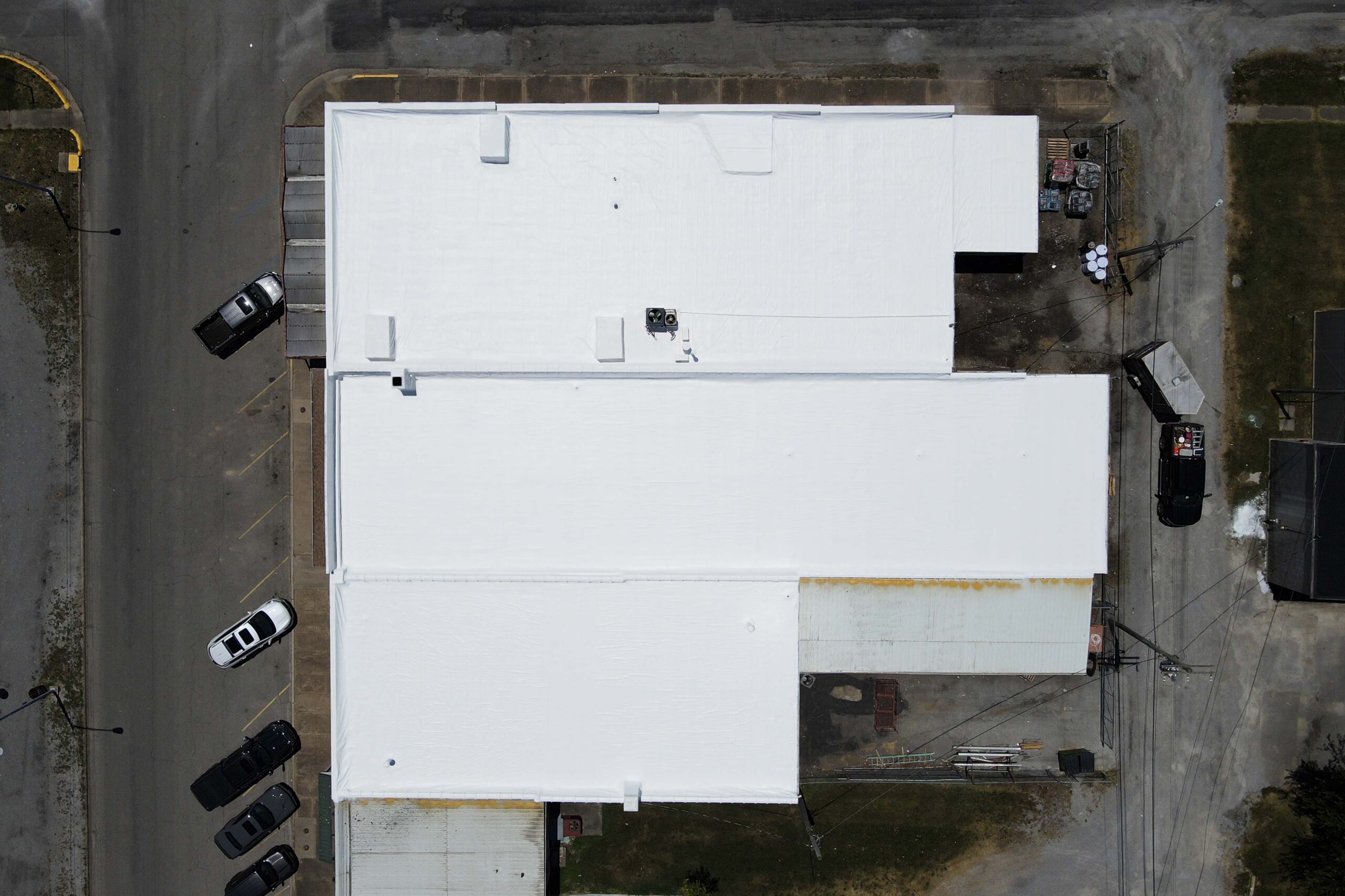 Aerial view of completed installation of a cool roofing system to the roof of a business by ArmorGuard.