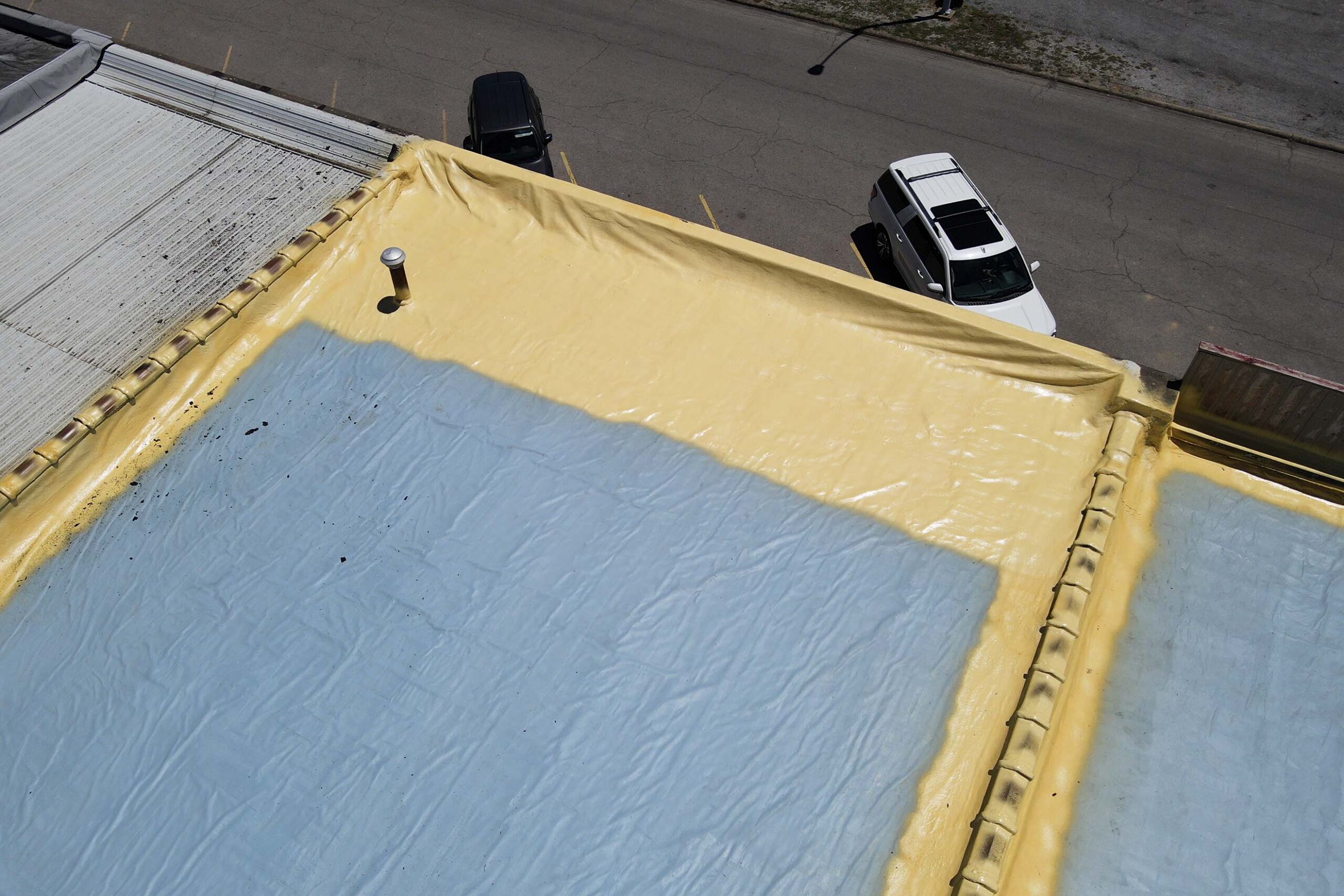 Cool roofing system being applied to the roof of a business by ArmorGuard.