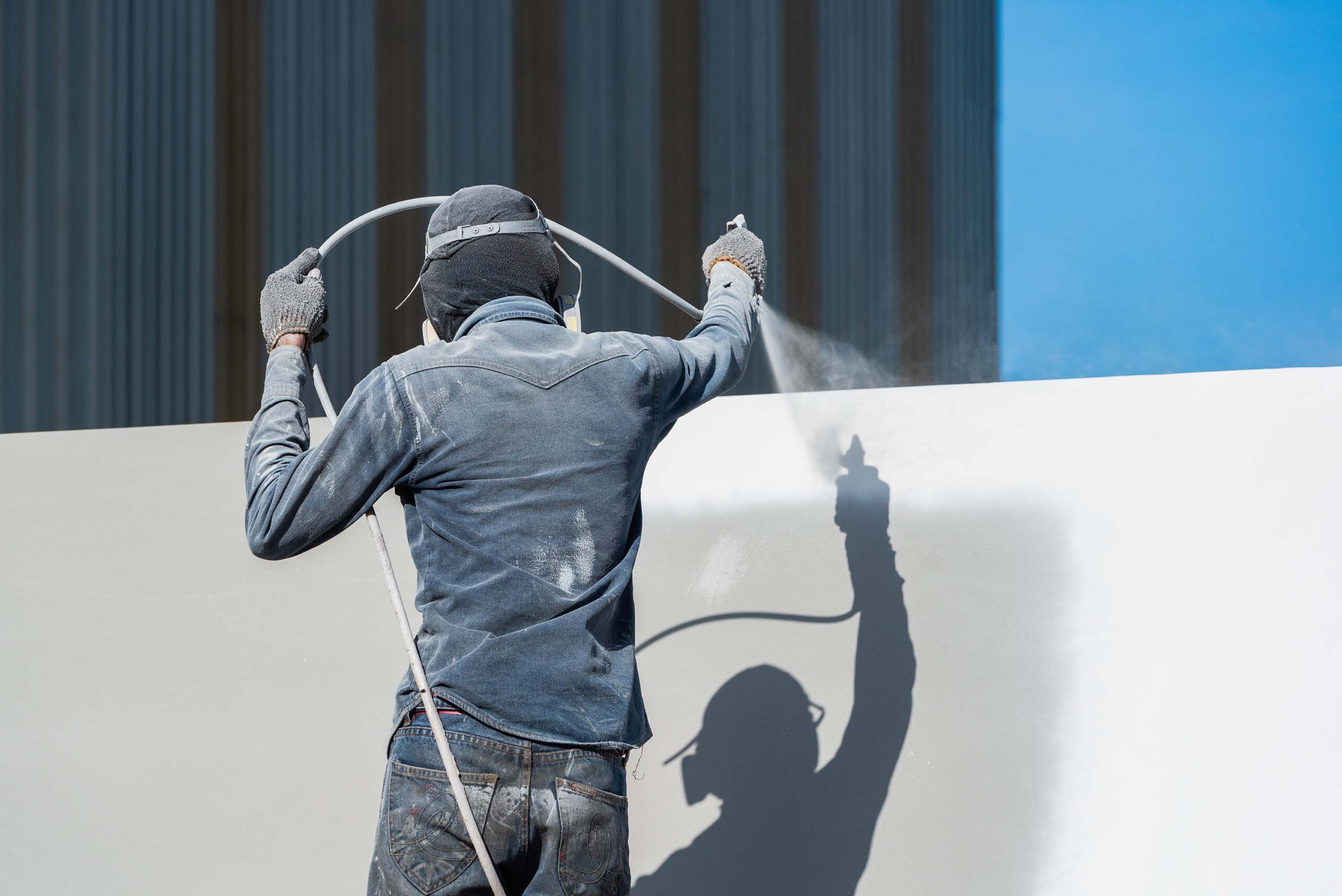 Polyurea coating being applied to the side of a building by ArmorGuard to add a protective barrier.