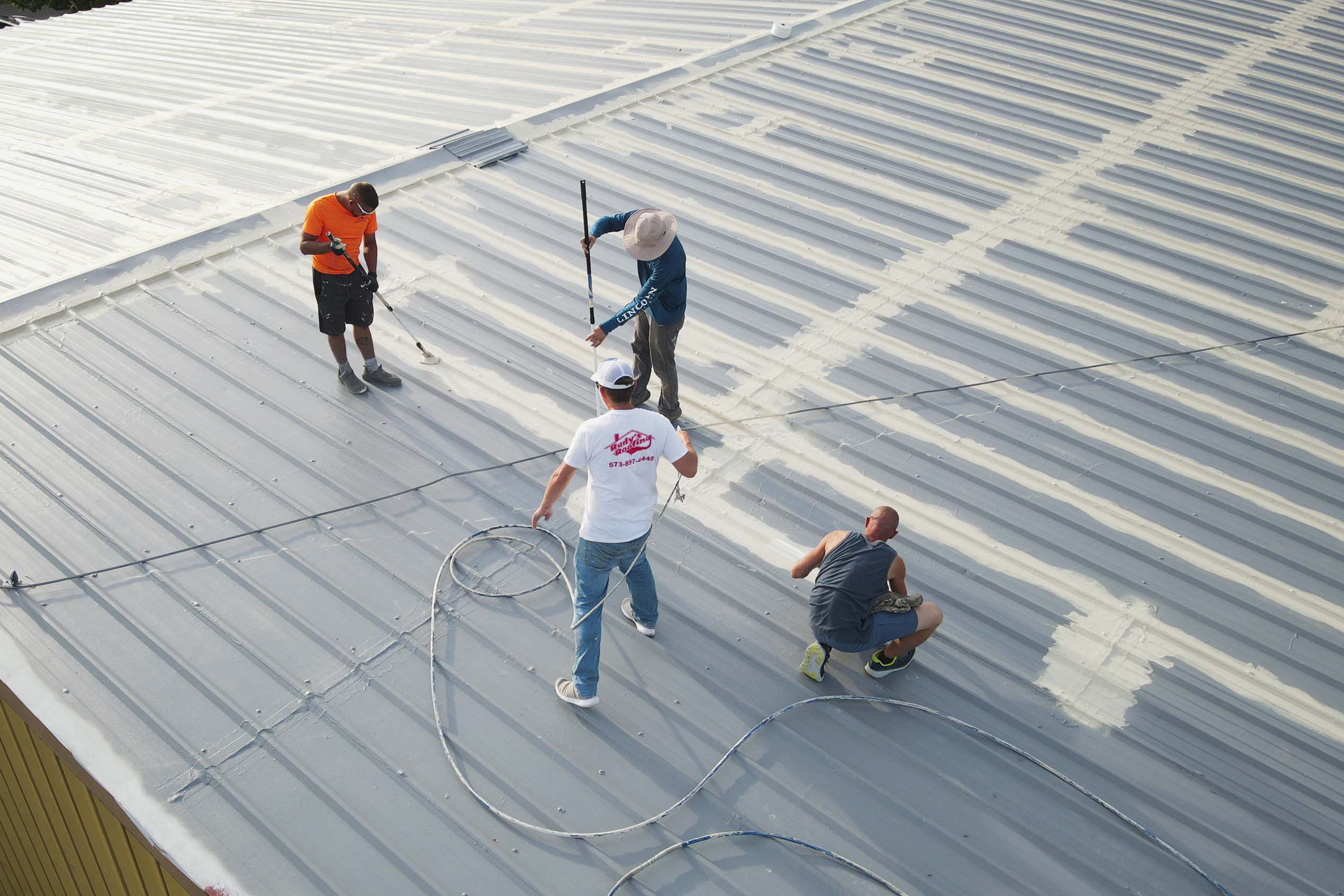 ArmorGuard team applying a roof coating to the roof of a building to prevent any future leaks.