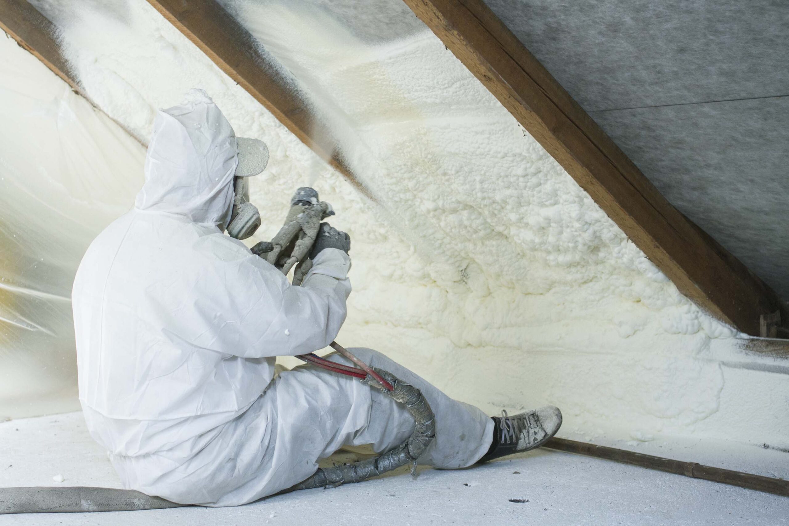 Spray foam insulation being installed by ArmorGuard in the attic of a home.